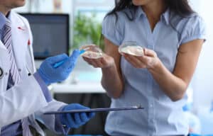 Close up of a doctor and a young woman discussing the best implant choices for her breast augmentation.